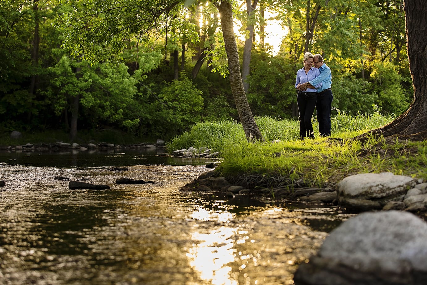 couple cuddling by stream for Williamstown engagement session