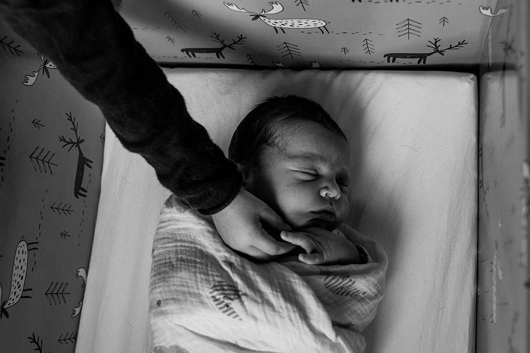 sister reaching into box to touch brother