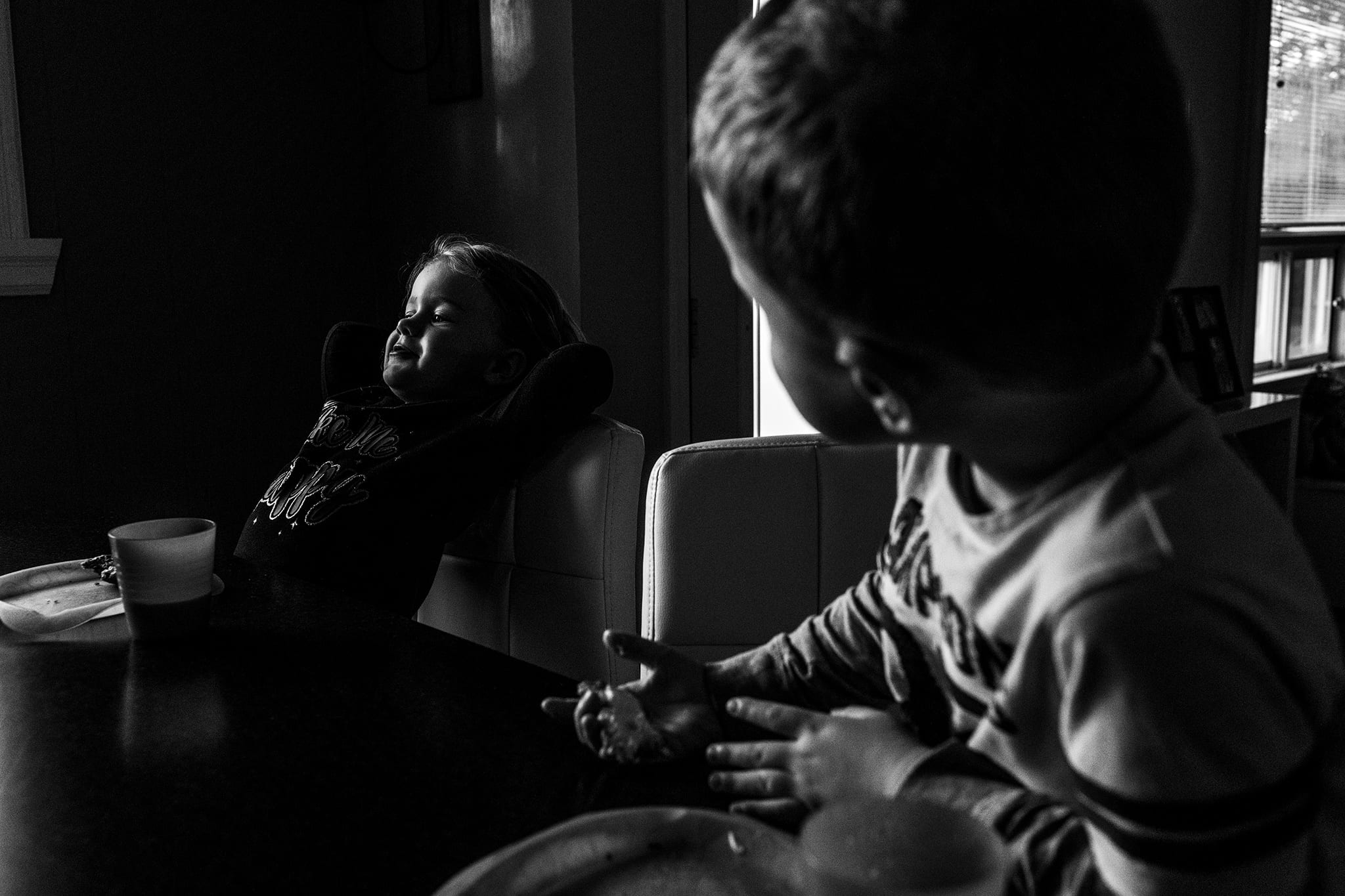 little girl stretches while eating breakfast during back-to-school documentary session