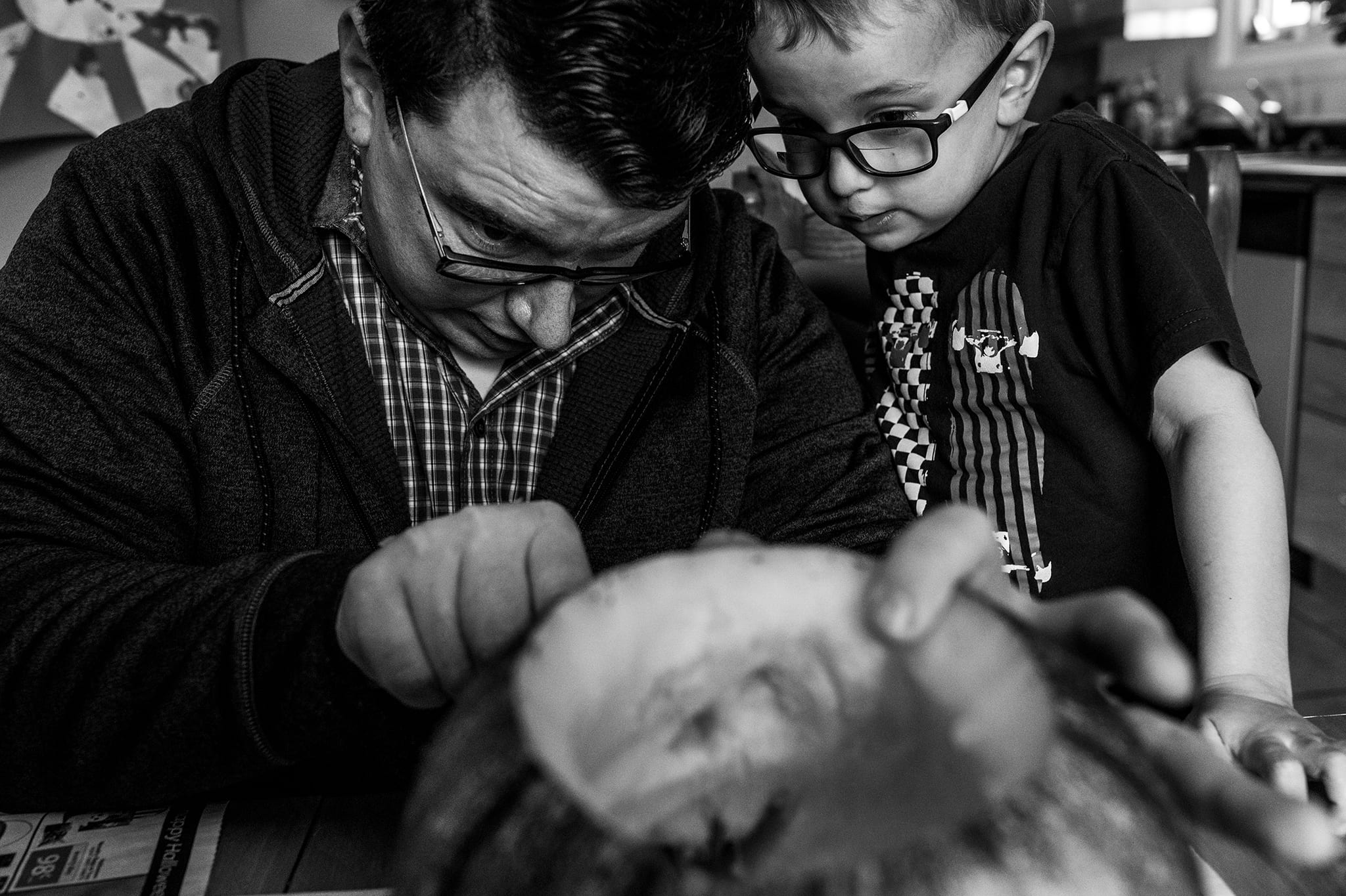 dad and son carve pumpkins