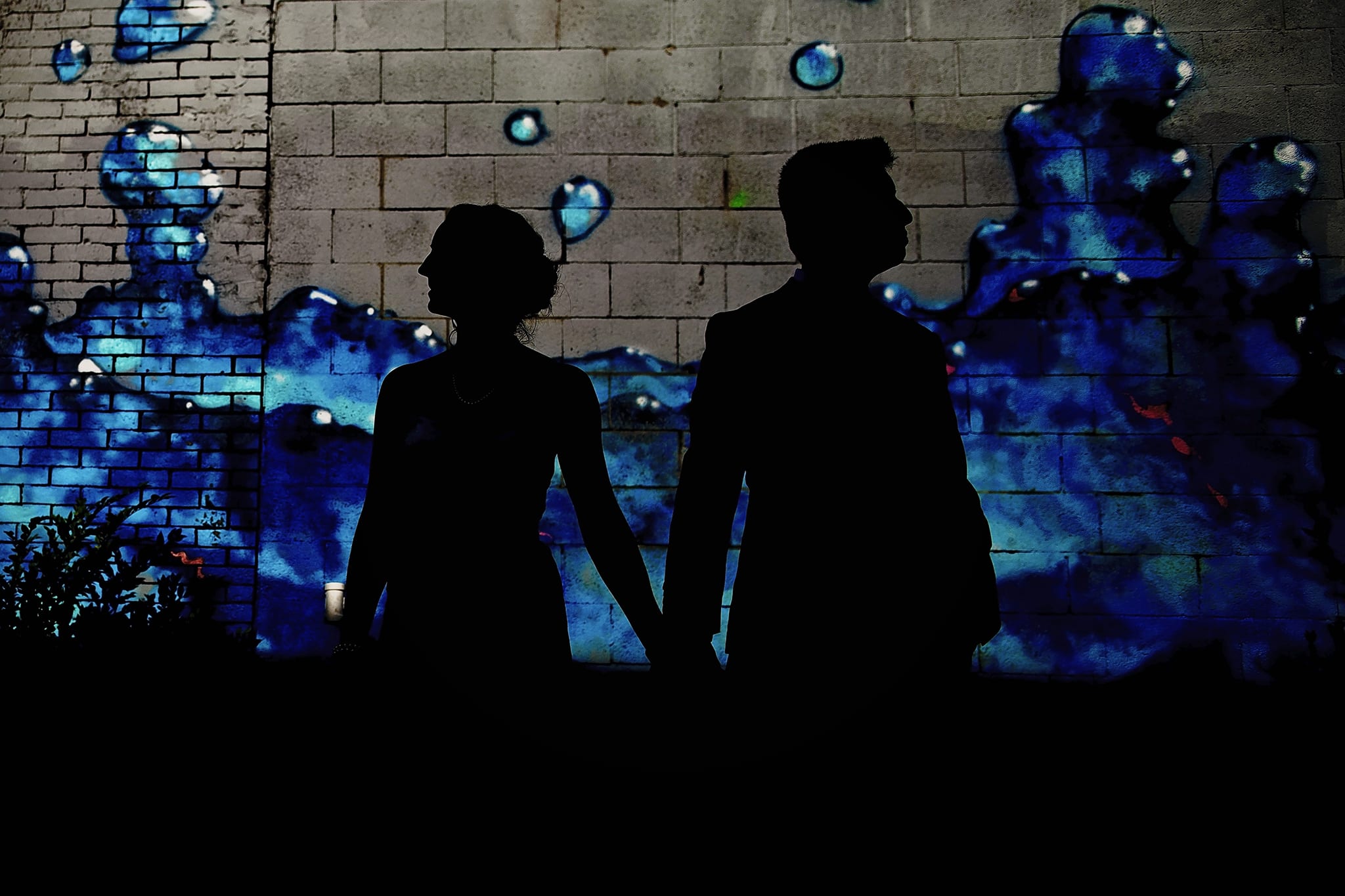 bride and groom in silhouette in front of Ottawa Chinatown graffiti of water