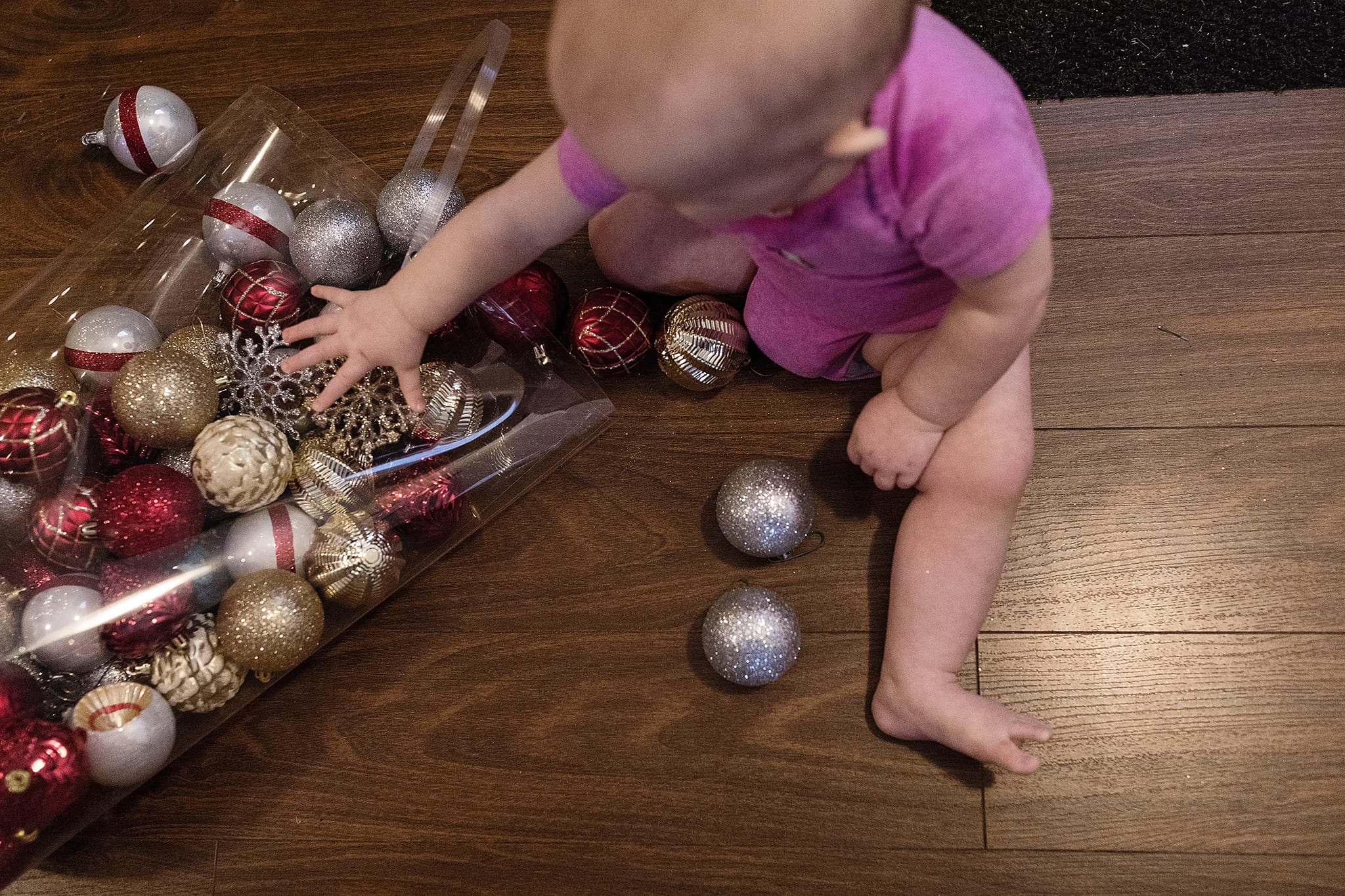 toddler plays with Christmas decorations