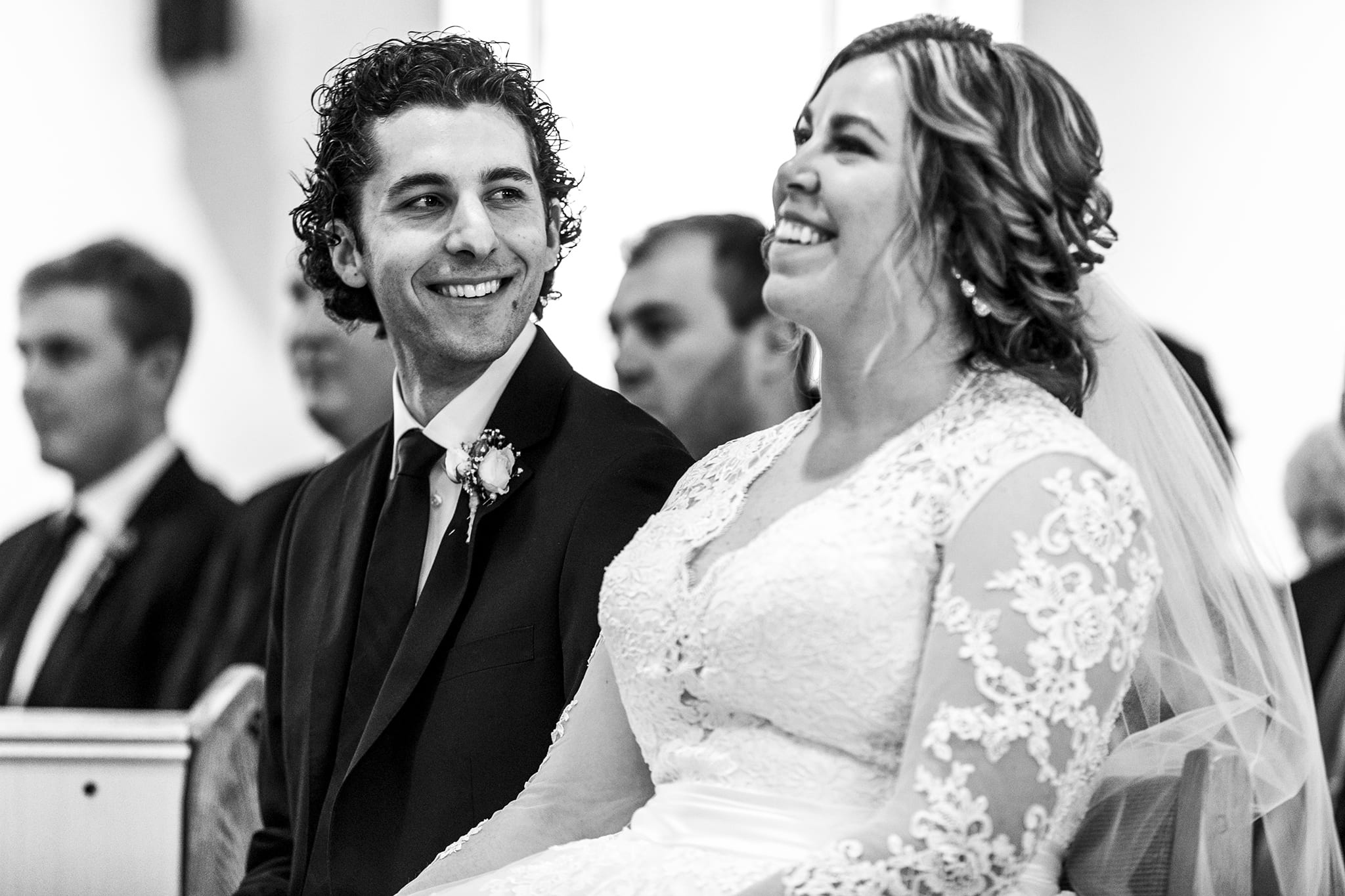 smiling groom looks at smiling bride during Cornwall wedding ceremony