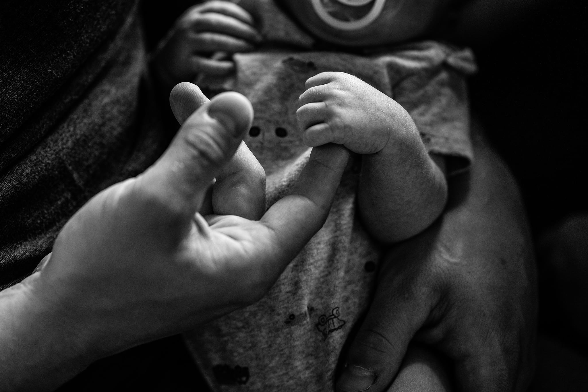 baby clutches father's finger