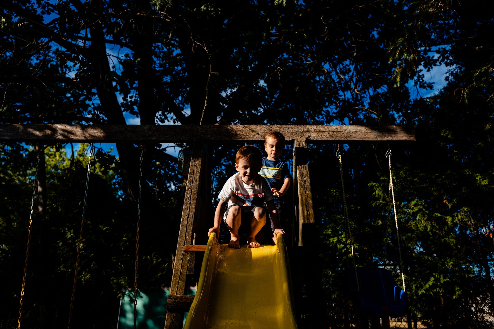 two boys stand on play structure during Cornwall Backyard Family Photos