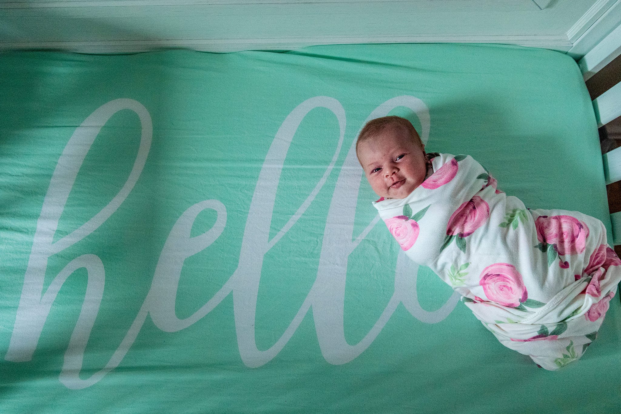 smiling baby lying on Target crib sheet printed with 