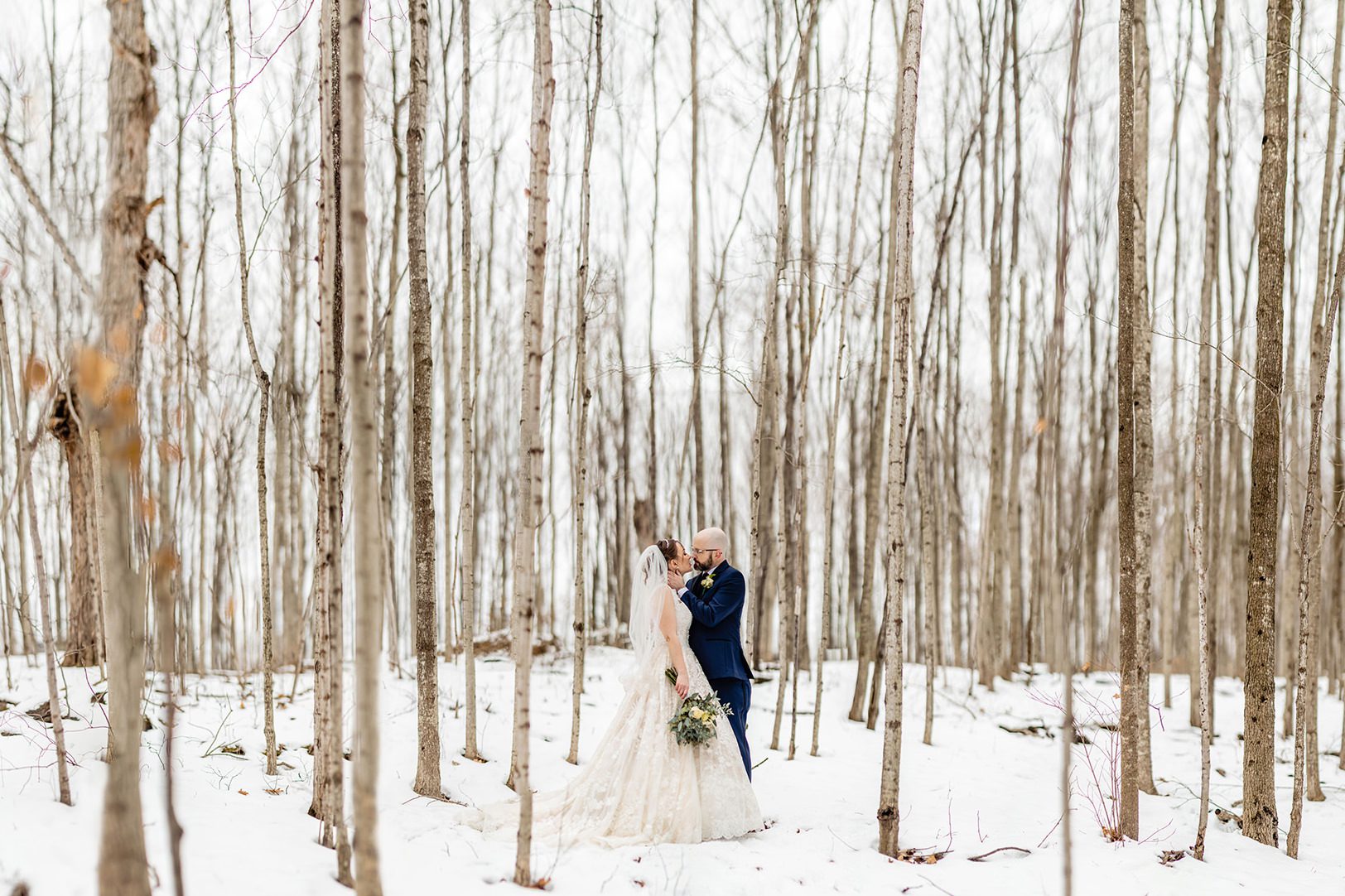 bride and groom in snowy Lamb's Pond forest