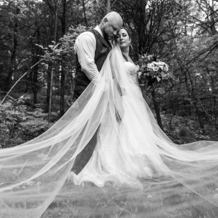 Groom and Bride posing together in a forest