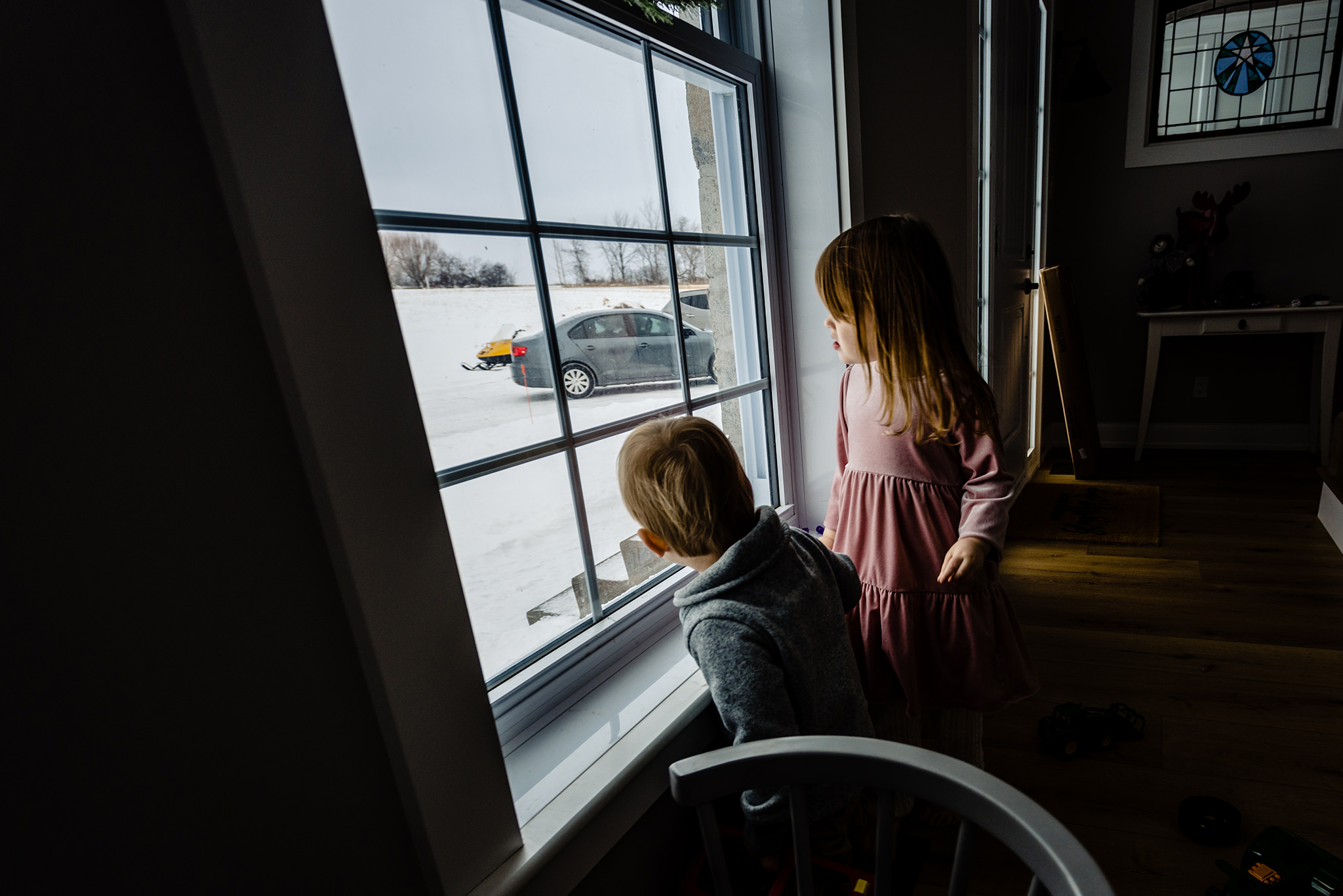 Two children watching out the window.