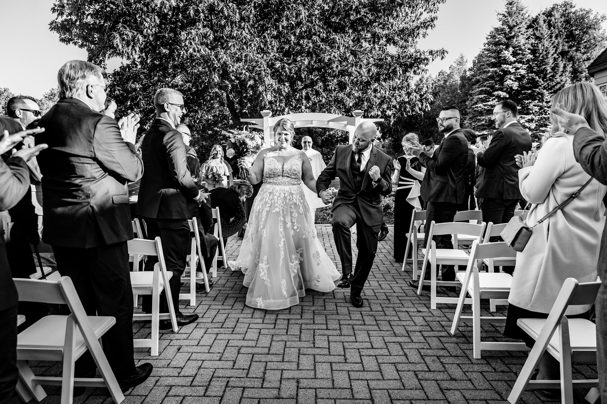 groom celebrates while walking with bride back down Rideauview Golf Course Wedding aisle