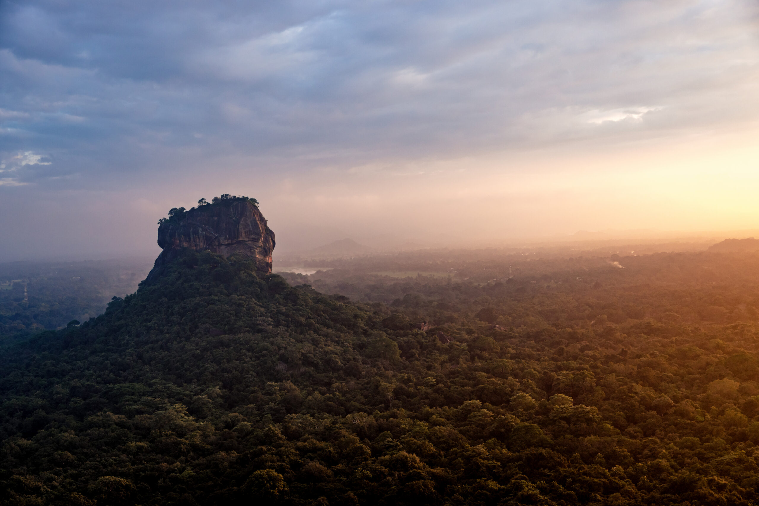 Sigiriya's Pidurangala Rock at sunset through the mist