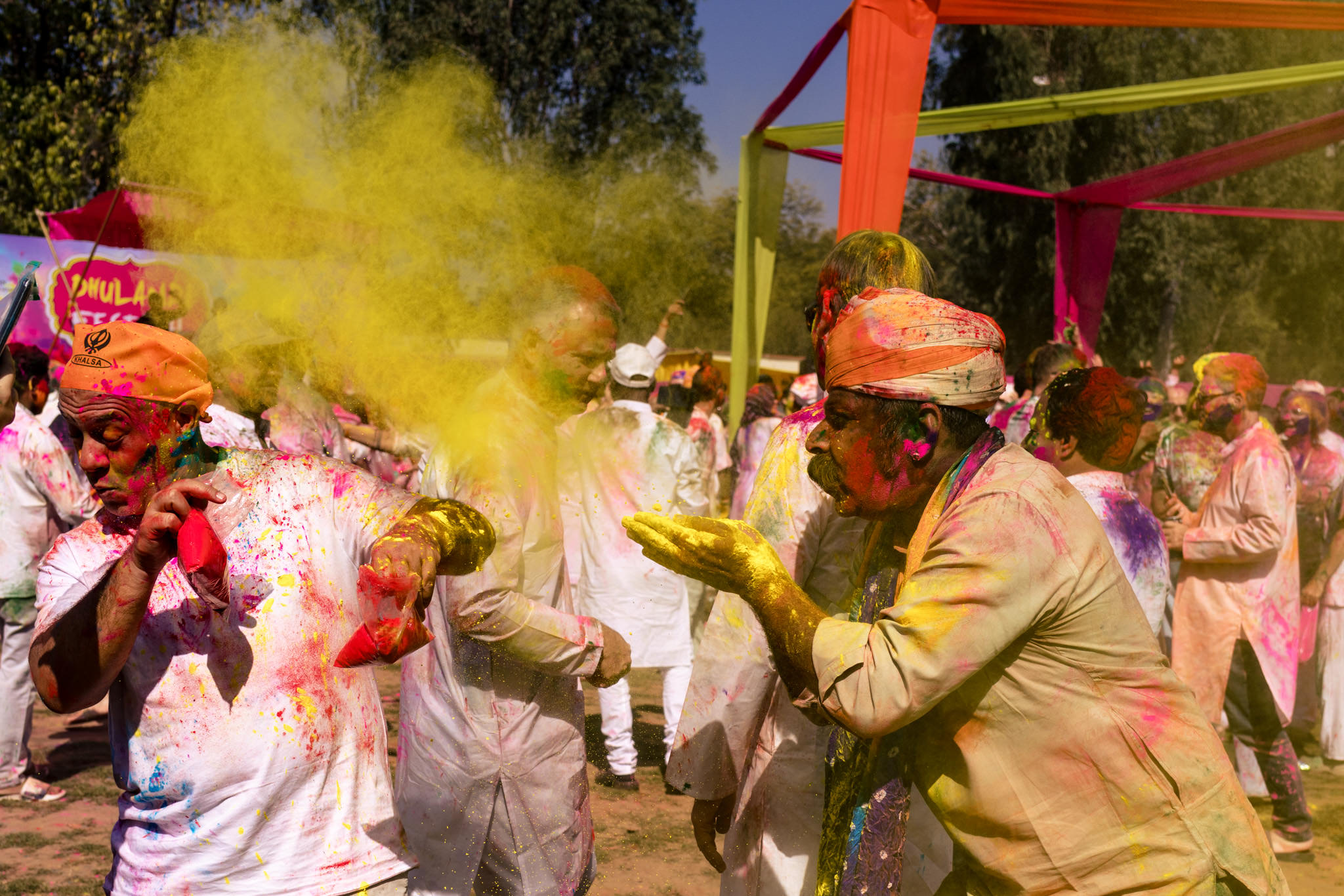 Man blows yellow paint powder on Holi attendee in Jaipur