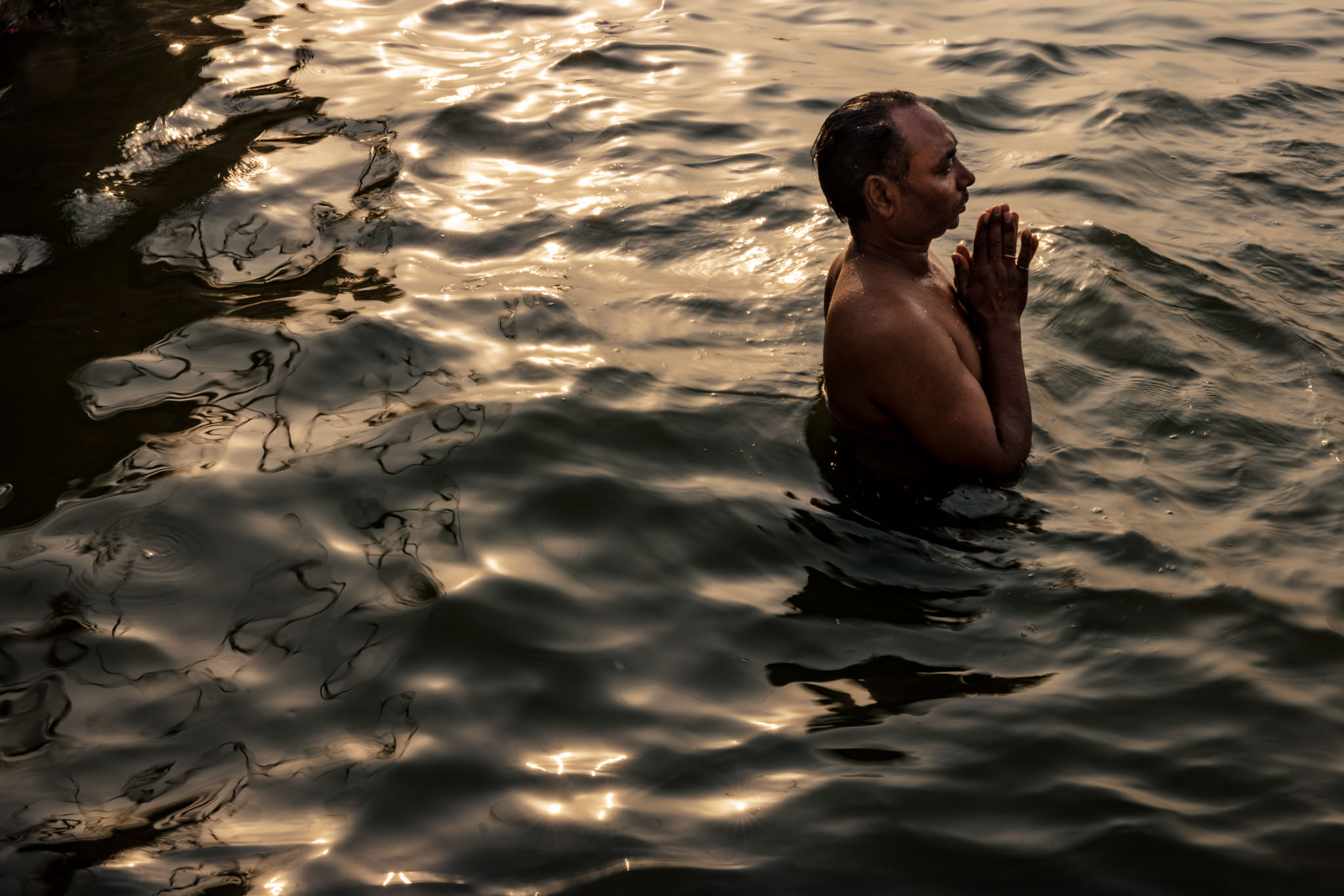 Man conducts Hindu ritual while standing in the Ganga in Varanasi
