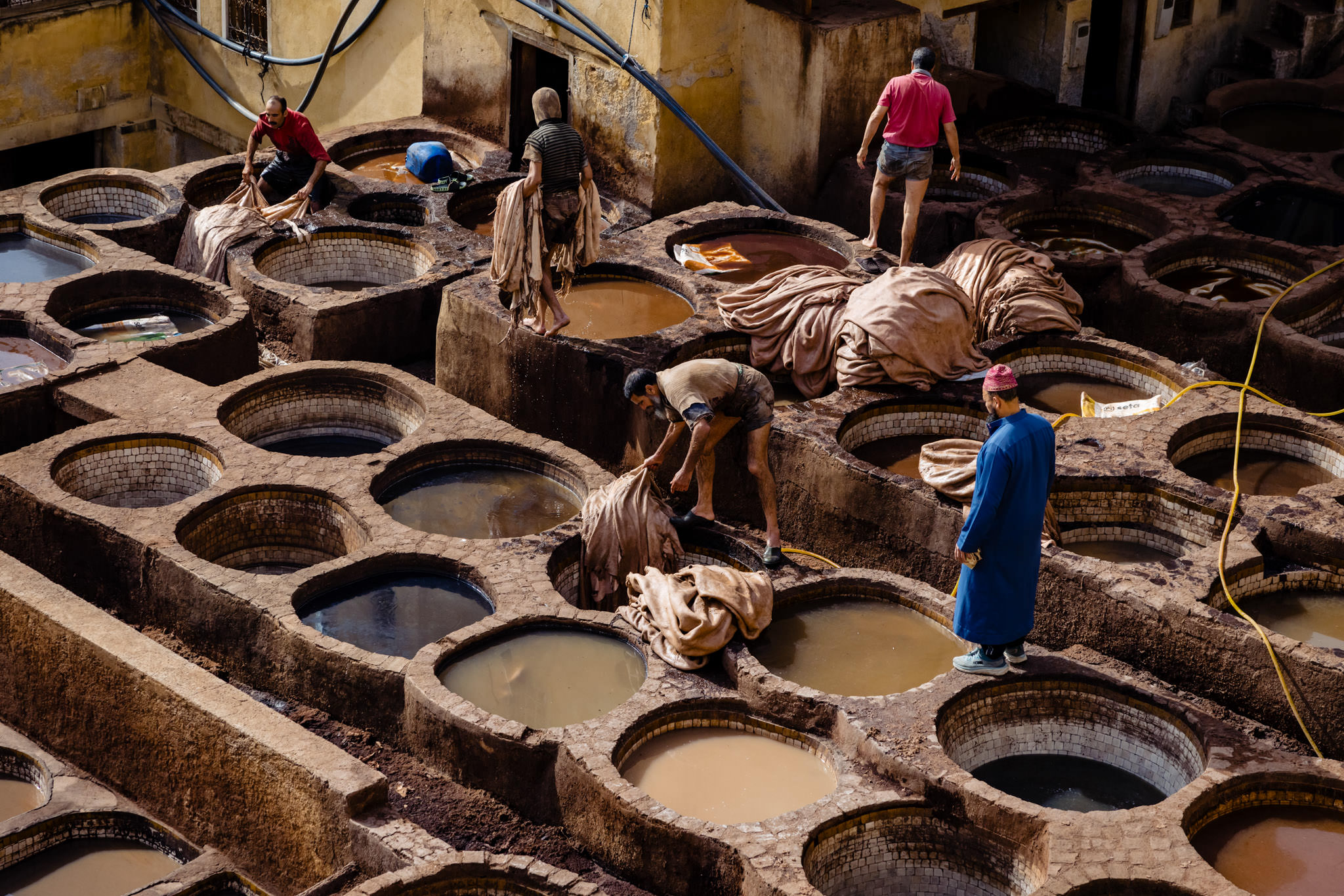 Chouara Tannery workers in Fes move between tanning pools
